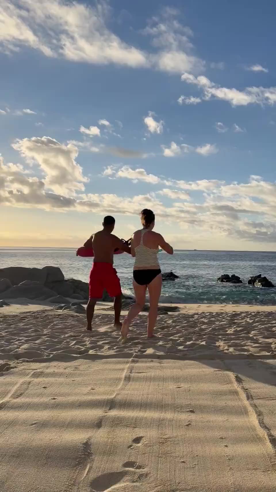 Tracy heading into the ocean at golden hour in Cabo