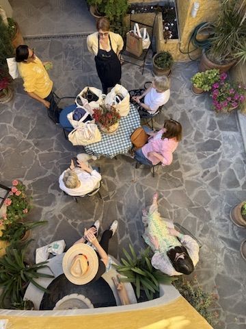 Women gathered around a courtyard table, seen from above