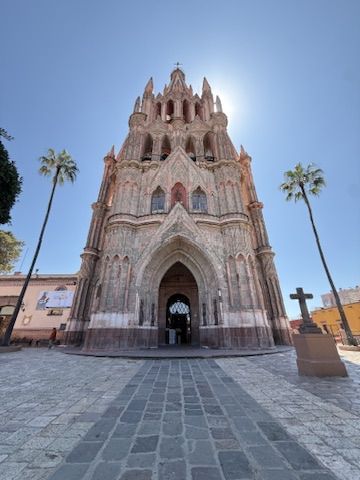 The Parroquia facade against a blue sky, framed by palm trees
